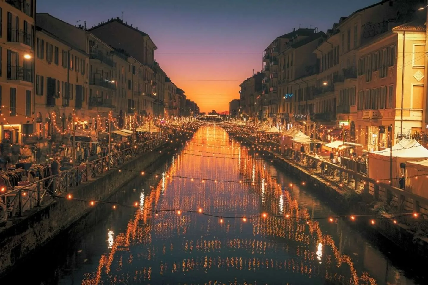 I Navigli di Milano con i locali riflessi nell'acqua al tramonto