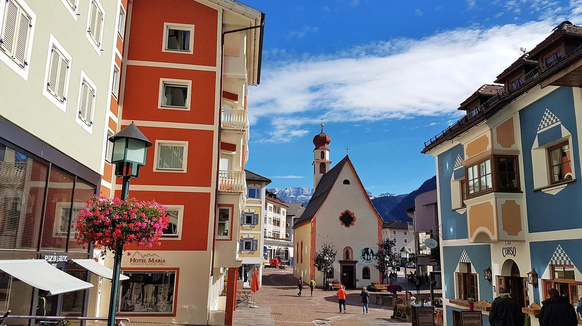 Il centro pedonale di Ortisei con il campanile e le Dolomiti sullo sfondo
