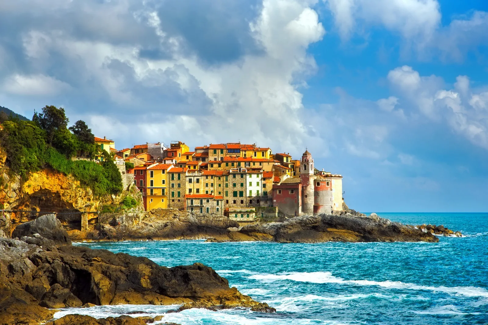 Il borgo di Tellaro con le case colorate a picco sul mare e la chiesa
