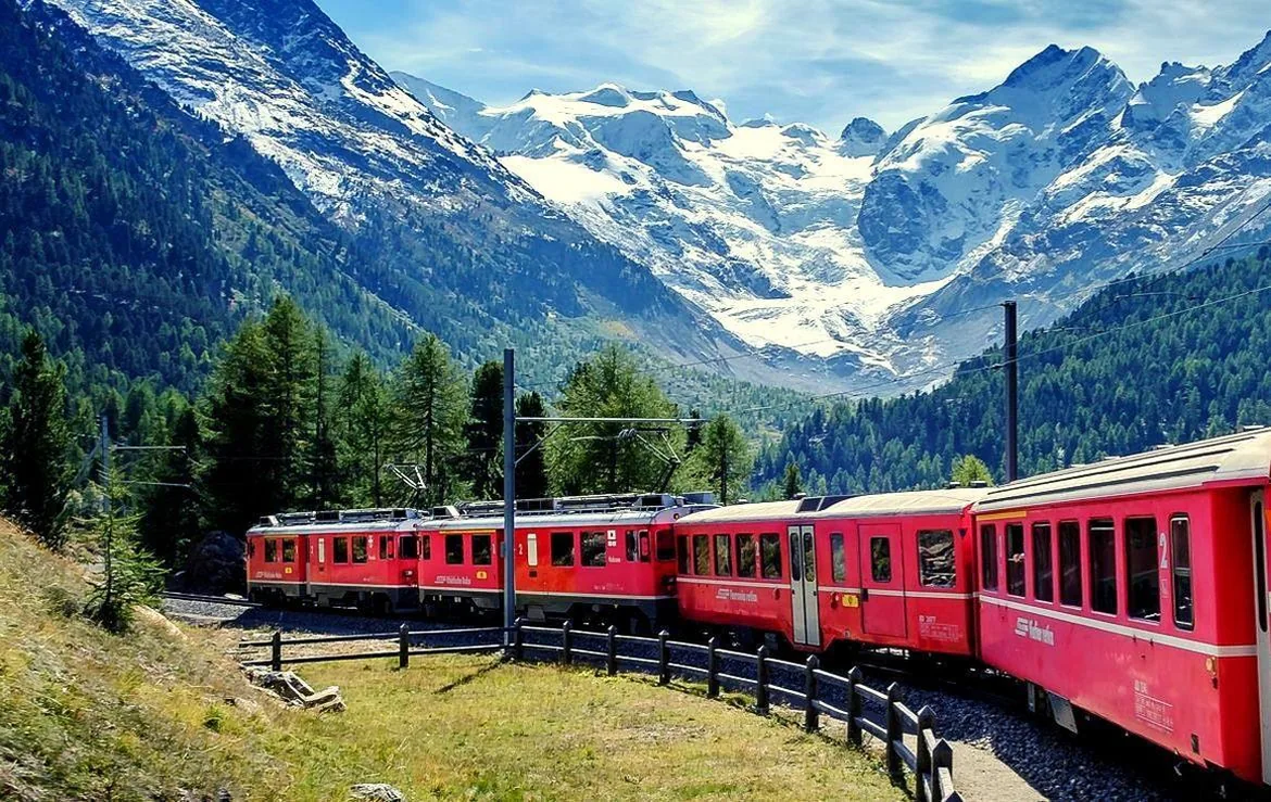 Il Trenino Rosso del Bernina in partenza da Tirano tra le montagne